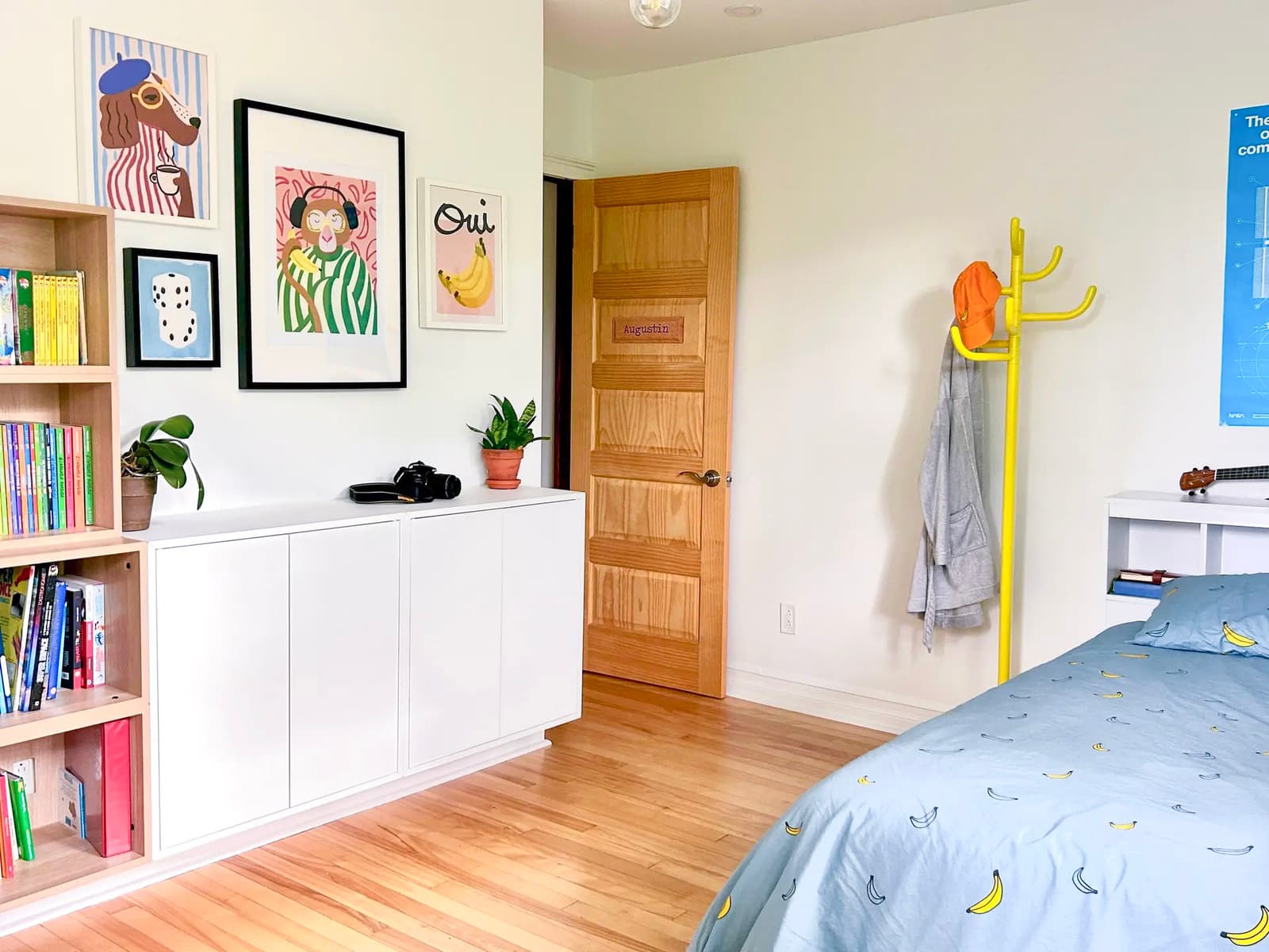 Chambre d’enfant avec décor coloré, plancher en bois clair et literie à motif de bananes.