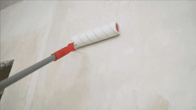 Application d'un primer avant peinture à la chaux sur mur&nbsp;