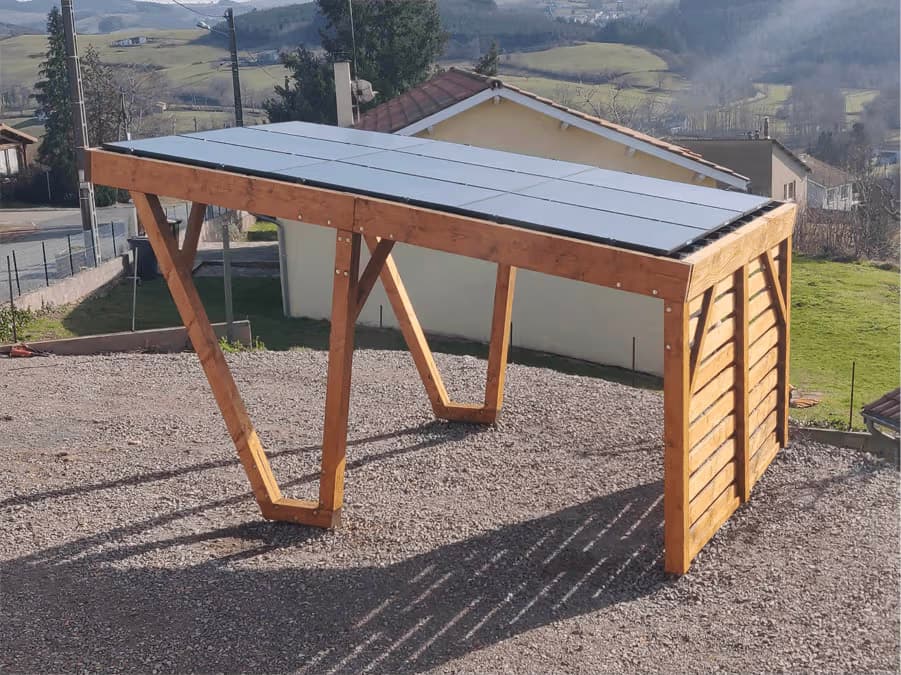 Pergola en bois avec toiture plate en panneaux métalliques sur terrain en gravier dans un environnement résidentiel rural.