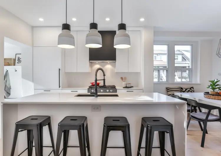 Cuisine moderne et lumineuse avec îlot central, plan de travail en quartz et électroménager en inox. Idéale pour les familles et les amateurs de cuisine ouverte