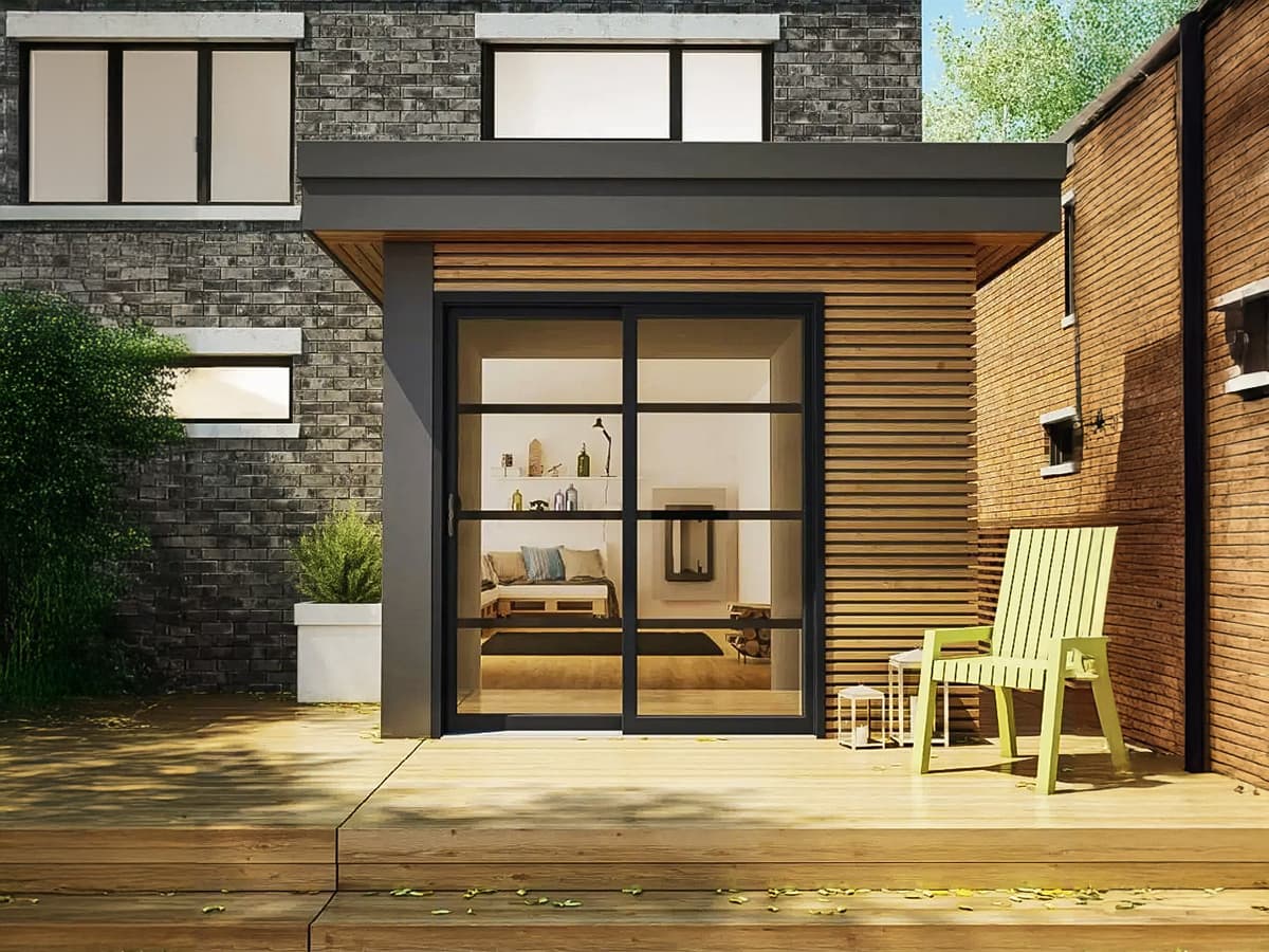 Façade moderne d'une maison contemporaine avec baie vitrée noire, bardage en bois et terrasse aménagée.