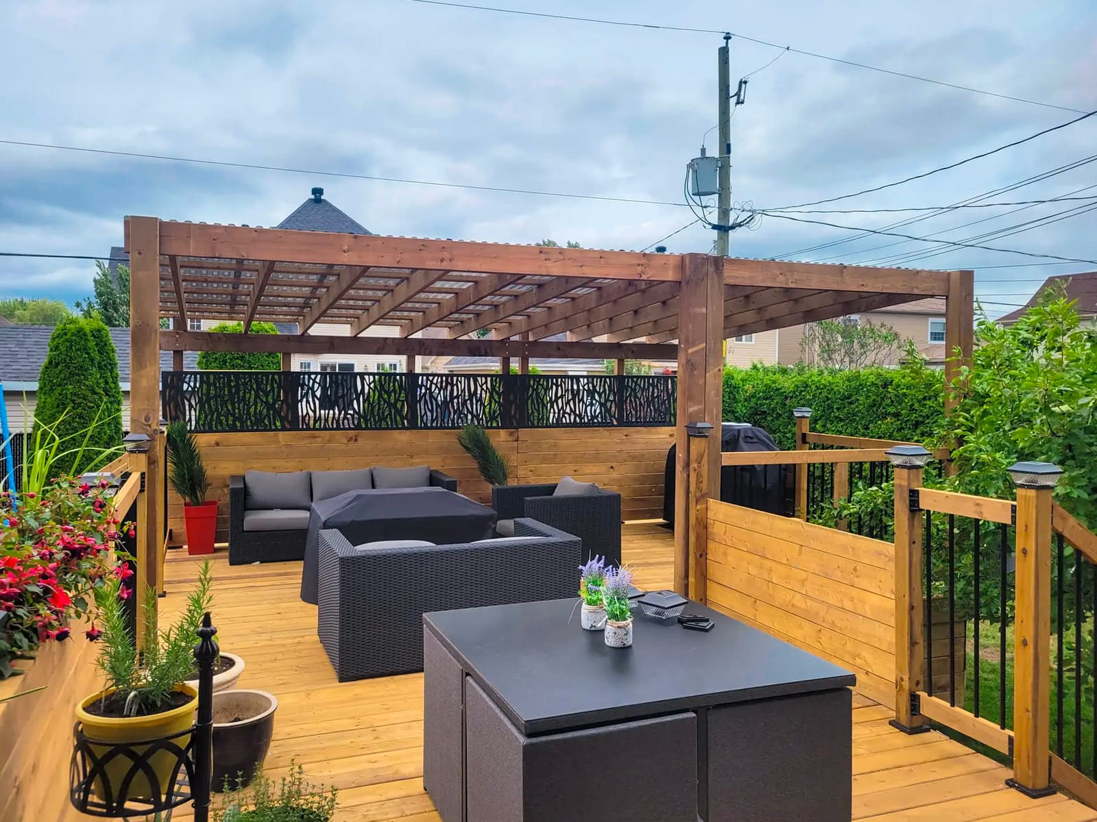 Terrasse en bois avec pergola en bois, mobilier extérieur moderne, panneaux métalliques décoratifs et éclairage extérieur, idéale pour les espaces extérieurs.