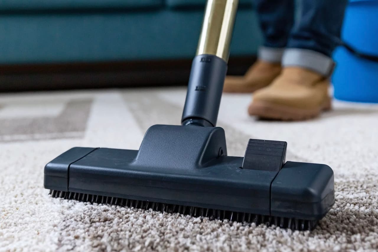 Nettoyage en profondeur d’un tapis résidentiel avec un aspirateur équipé d’une brosse pour l’entretien intérieur de la maison.