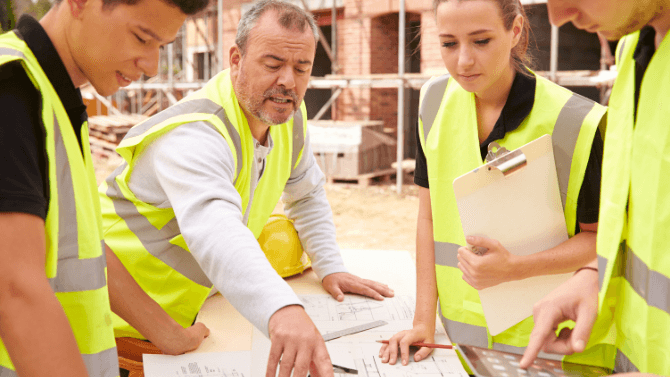 Jeunes apprentis travaillant sur un chantier de construction sous la supervision d'un compagnon