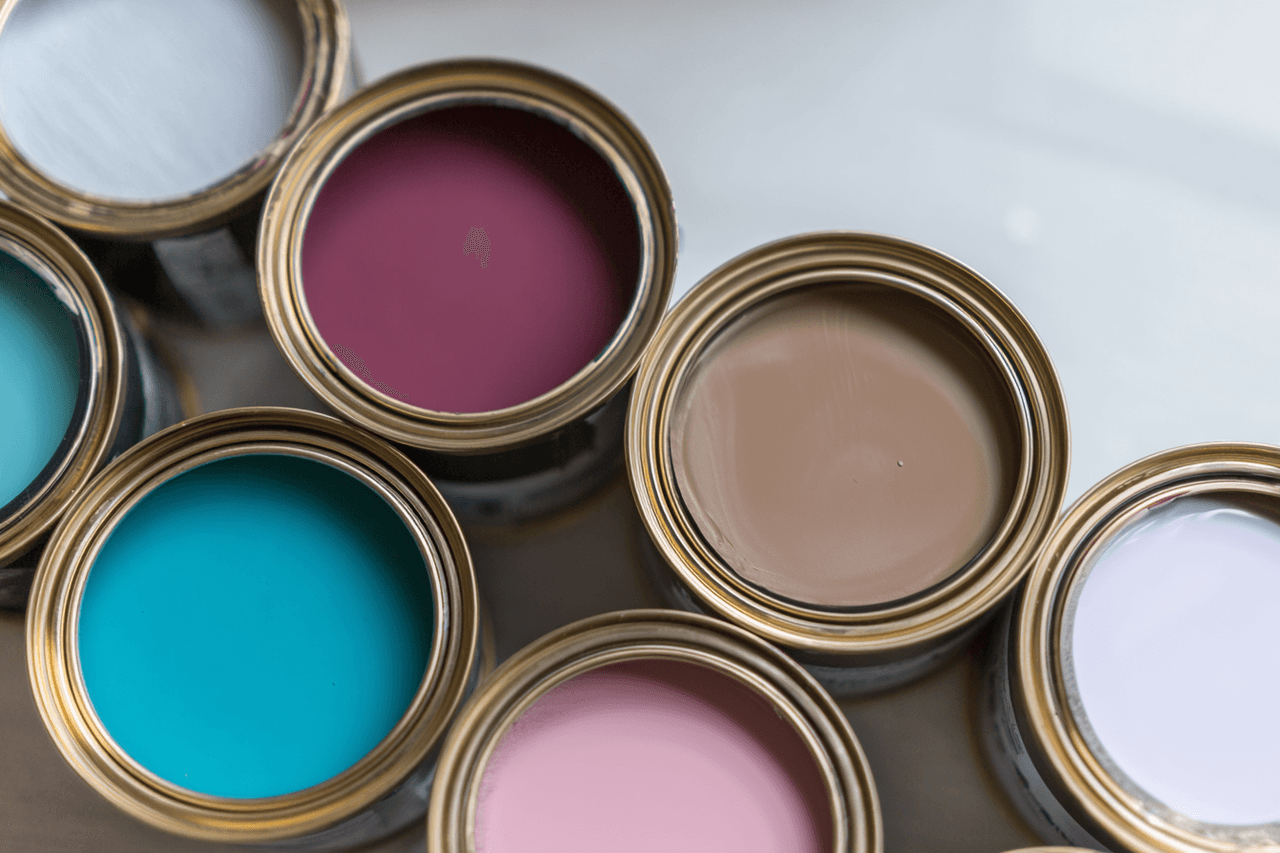 Pots de peinture ouverts avec différentes couleurs vives sur fond neutre