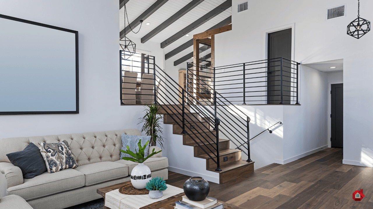 Salon moderne à aire ouverte et paliers multiples avec un canapé capitonné, un escalier en bois à rampes noires et un plafond à poutres apparentes