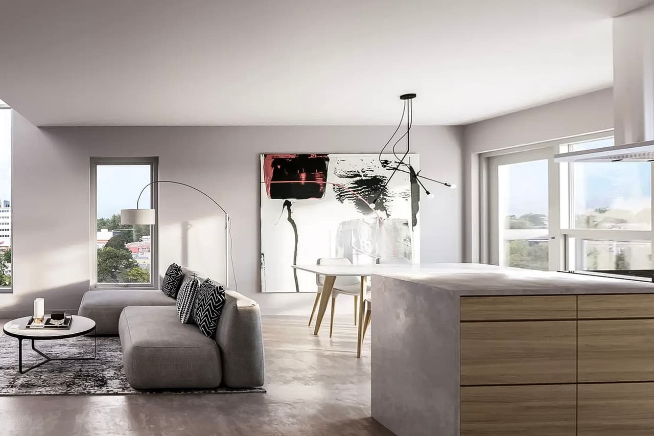 Salon et cuisine à aire ouverte au design moderne et minimaliste, avec un sol en béton poli, un îlot en bois et béton, et de grandes fenêtres laissant entrer la lumière naturelle.