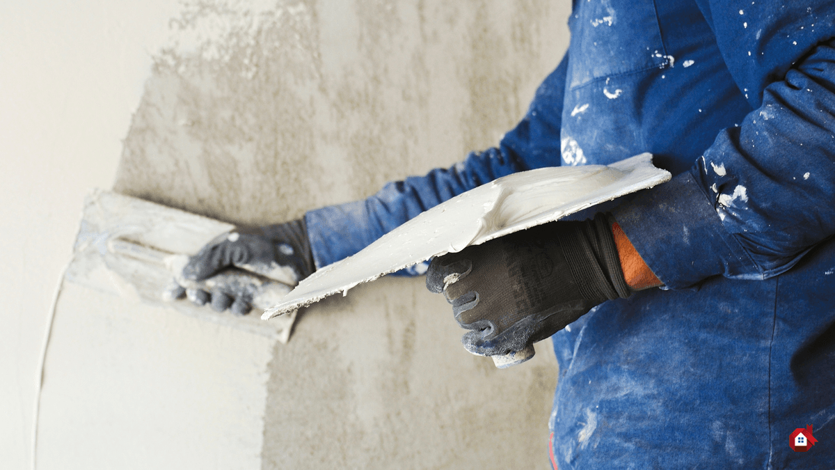 entrepreneur mettant du crépi sur le mur