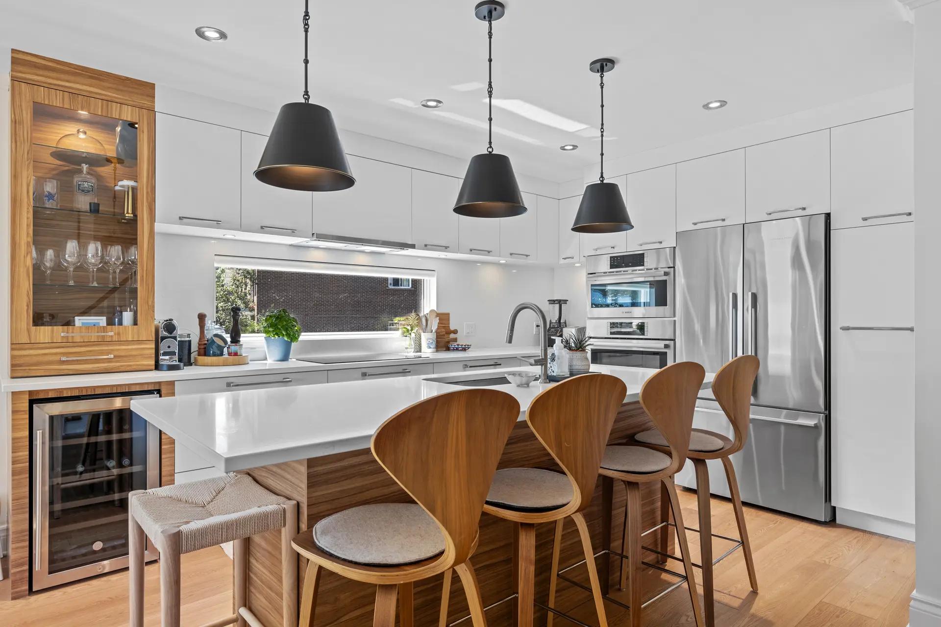 cuisine chaleureuse et accueillante alliant bois et blanc. L'îlot central en bois clair crée un espace convivial pour les repas en famille ou entre amis