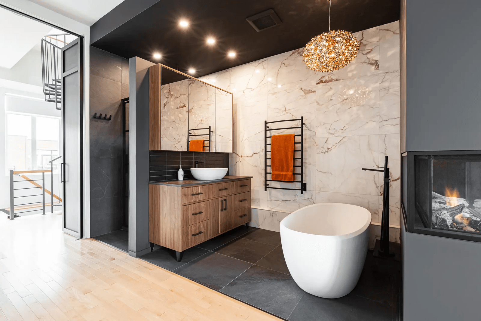 Salle de bain contemporaine avec un bain autoportant, une douche à l'italienne, un plancher de bois et des carreaux de marbre.