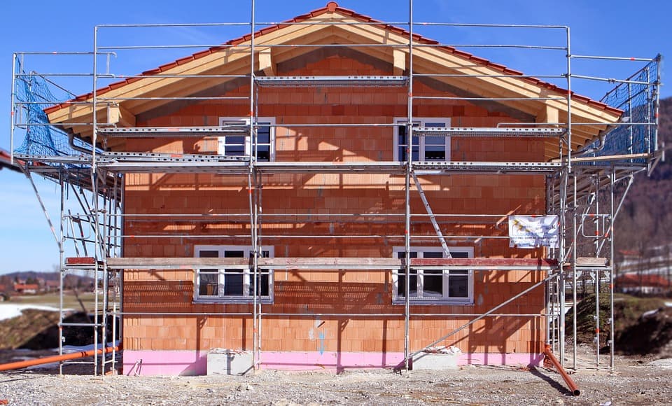 Maison en rénovation avec échafaudages et bâches de protection