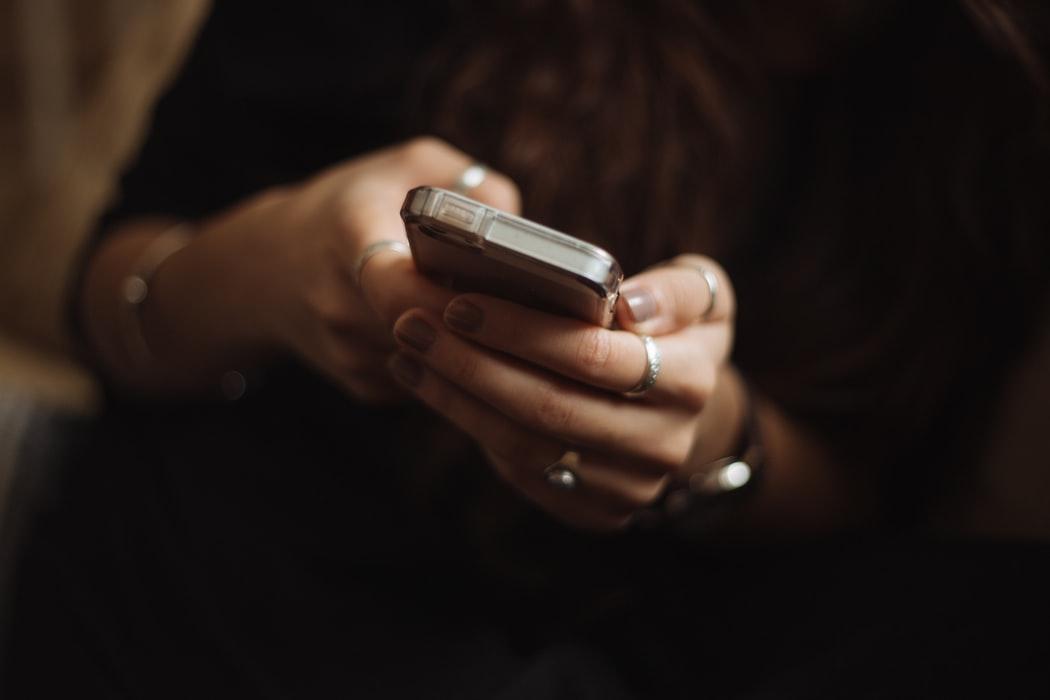 femme tenant un téléphone_Les arnaques liées à l'énergie: comment les éviter