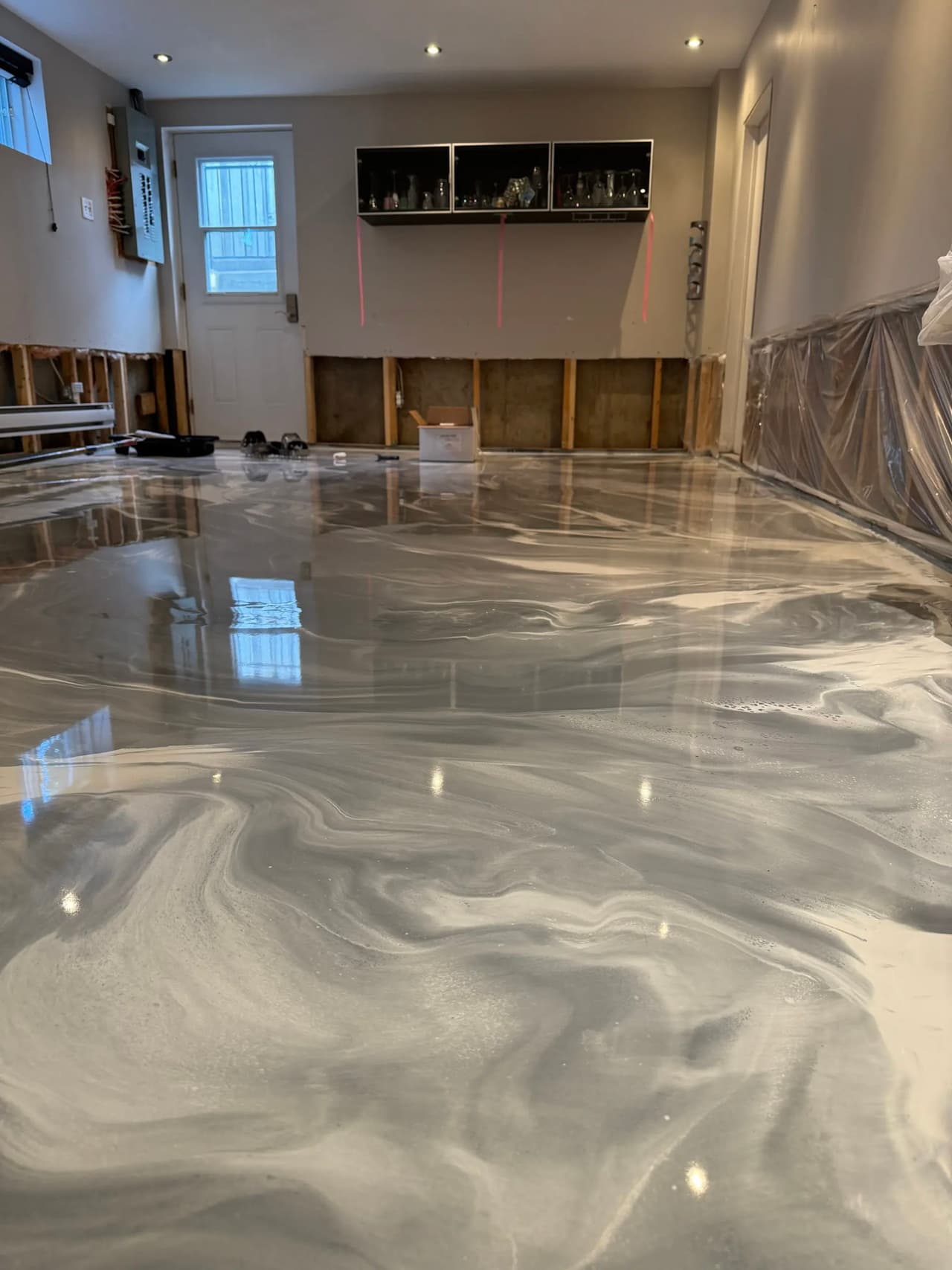 Plancher époxy gris et blanc à effet marbré dans une pièce résidentielle en rénovation.
