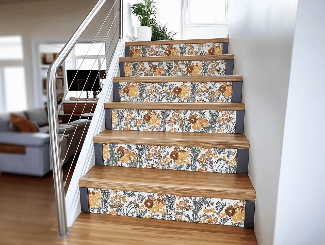 Escalier intérieur en bois clair avec contremarches décorées d’un motif floral jaune, orange et vert, rampe métallique moderne et mur blanc lumineux.