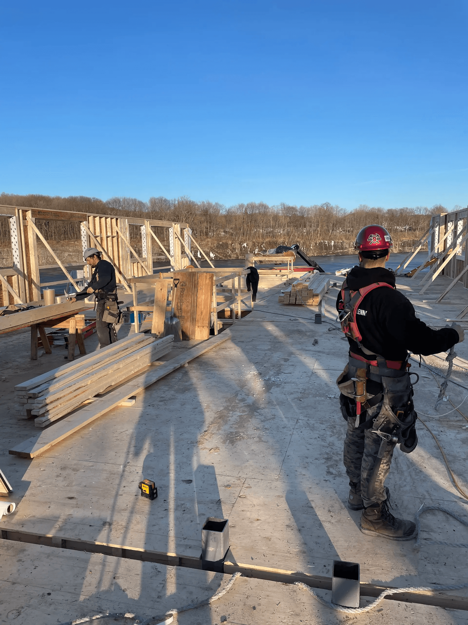 Travailleurs de la construction sur un chantier de charpente en bois au stade initial d’une maison