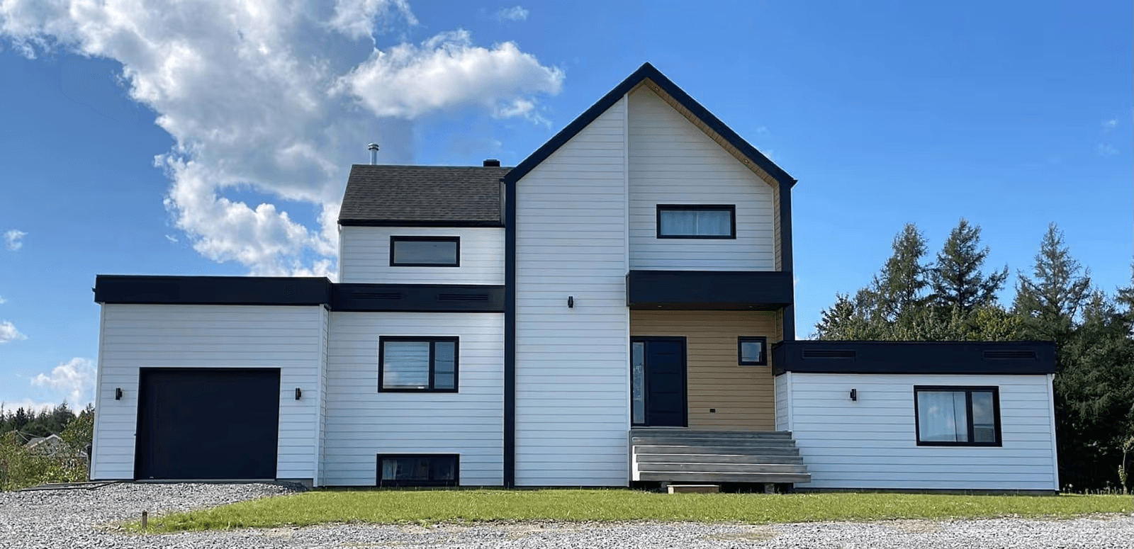 Maison moderne à deux étages avec revêtement extérieur blanc et accents noirs, garage intégré et entrée surélevée