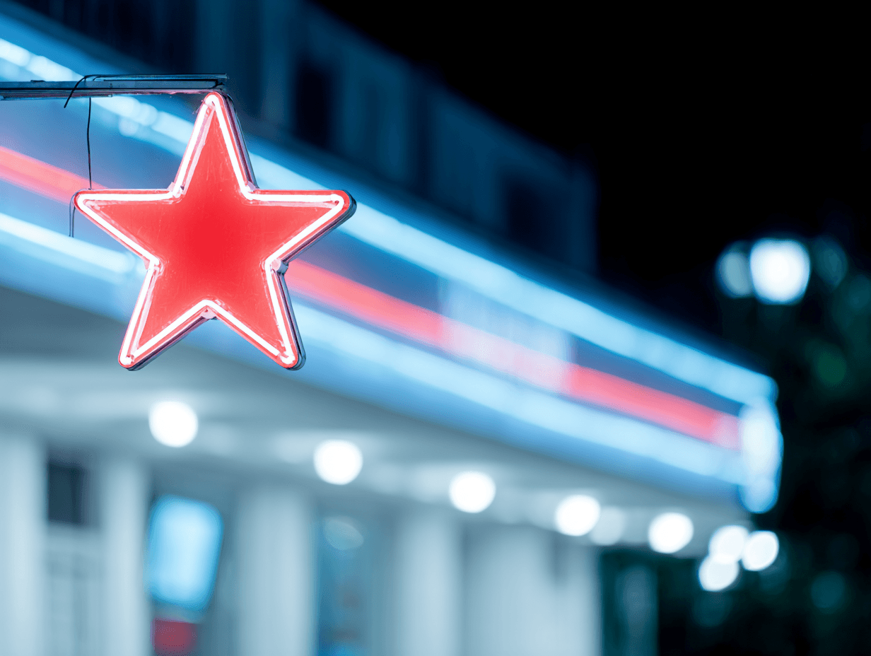 Red star-shaped illuminated sign with blue and red neon lighting on a commercial storefront at night