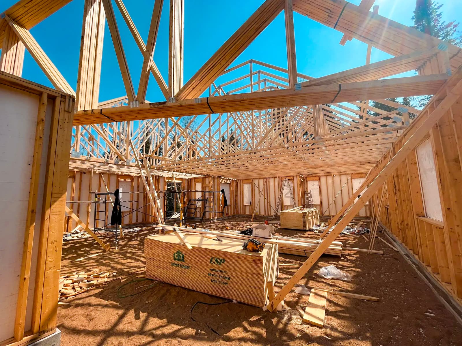 Charpente en bois d'une maison en construction avec fermes de toit exposées