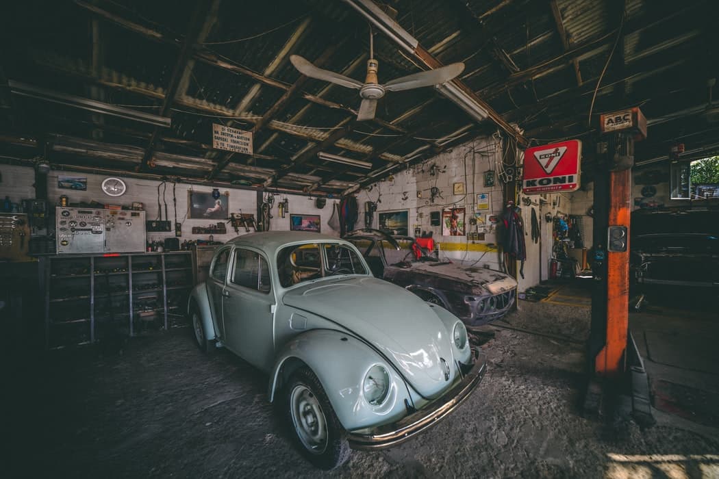 Voiture ancienne de collection garée à l'intérieur d'un atelier-garage mécanique vintage.