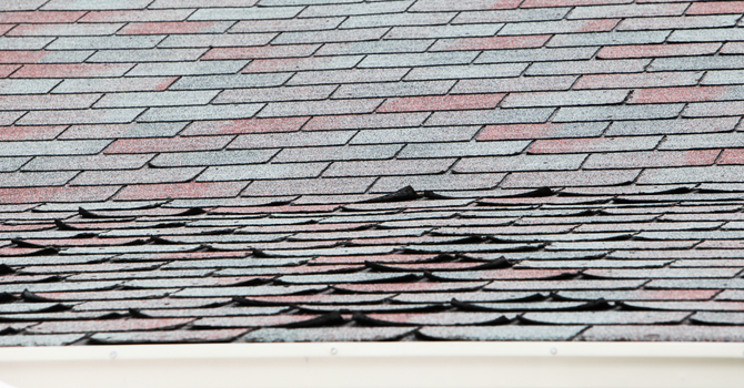 maison avec toiture noire_Solutions pour un toit endommagé par le vent : le remplacement ou la réparation