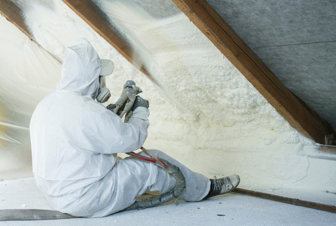 Contractor spraying polyurethane foam insulation