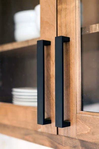 Poignées noires sur armoires en bois